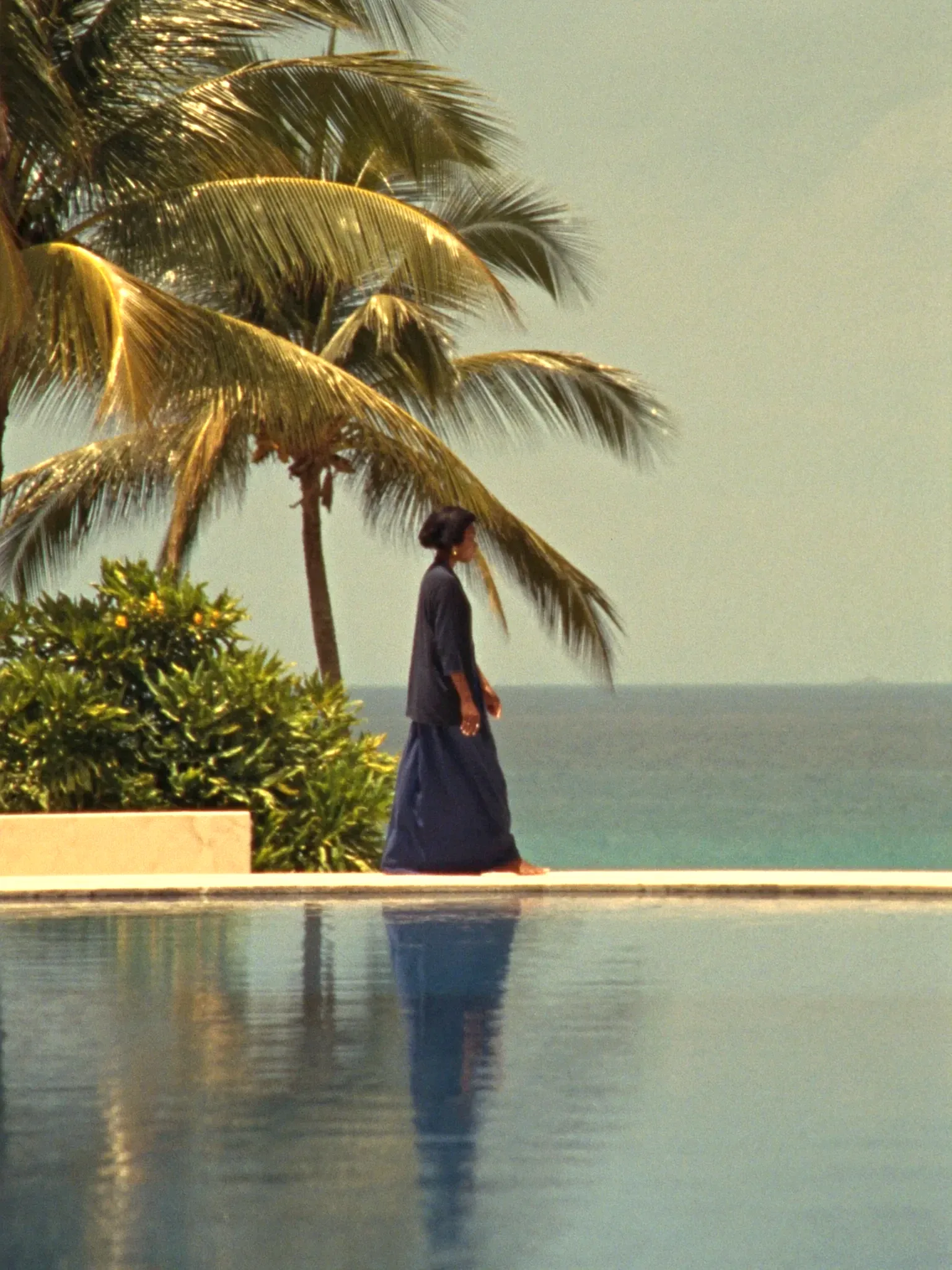 A guest walking calmly along an infinity pool (placeholder)